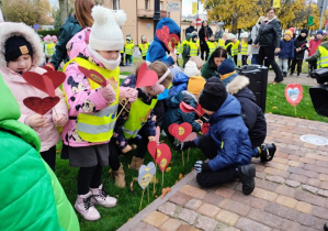 Dzieci wbijają serduszka w trawnik