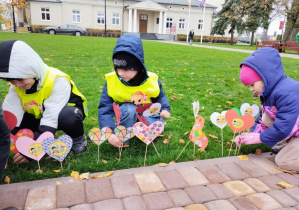 Dzieci wbijają serduszka w trawnik