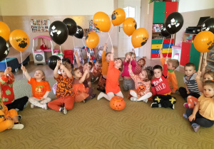 Dzieci pozują do zdjęcia trzymając balony