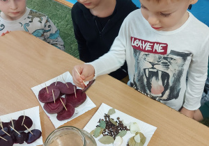 Chłopiec wkłada plaster buraka do słoika