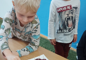 Chłopiec wkłada plaster buraka do słoika