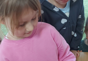 Dziewczynka wkłada plaster buraka do słoika