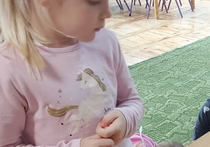 Dziewczynka wkłada plaster buraka do słoika