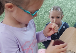 Dziewczynka wkłada plaster buraka do słoika