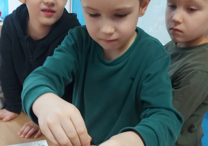 Chłopiec wkłada plaster buraka do słoika