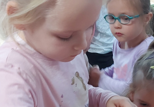 Dziewczynka wkłada plaster buraka do słoika