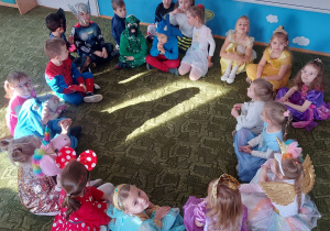 Dzieci siedzą w kole na dywanie