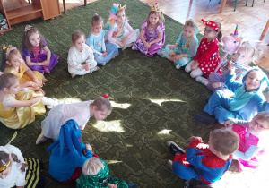 Dzieci siedzą w kole na dywanie