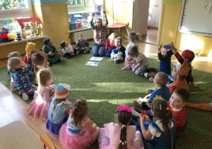 Dzieci siedzą w kole na dywanie