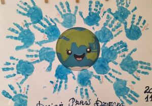 Praca plastyczna z odbitymi w niebieskiej farbie dłońmi dzieci