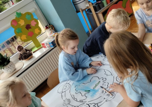 Dzieci kolorują kolorowankę dotyczącą praw dziecka