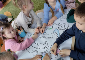 Dzieci kolorują kolorowankę dotyczącą praw dziecka