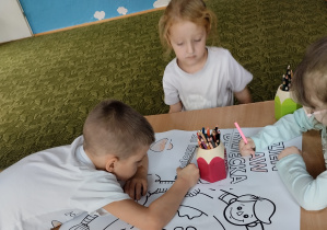 Dzieci kolorują kolorowankę dotyczącą praw dziecka