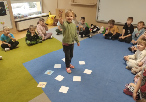 Dziewczynka pokazuje kartkę z misiem