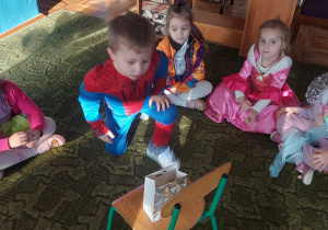 Dzieci siedzą na dywanie
