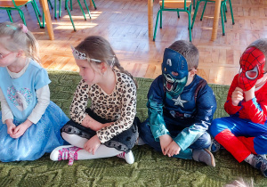 Dzieci siedzą na dywanie