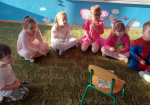 Dzieci siedzą na dywanie czekając na wróżbę