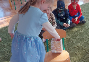 Dziewczynka losuje serduszko z wróżbą