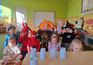 Dzieci pozują do zdjęcia w strojach andrzejkowych