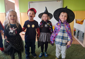 Dzieci pozują do zdjęcia w strojach andrzejkowych