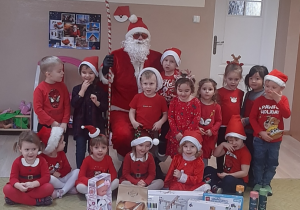 Dzieci pozują do zdjęcia z Mikołajem