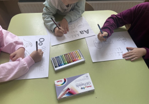 Dzieci wykonują zadania na kartce