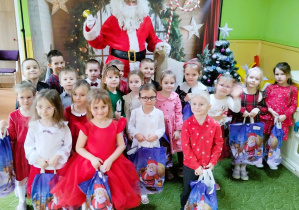 Dzieci pozują do zdjęcia z Mikołajem