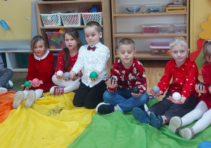 Dzieci siedzą na chuście animacyjnej