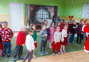 Dzieci w trakcie balu świątecznego stoją w sali