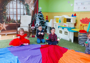 Dzieci siedzą na chuście animacyjnej