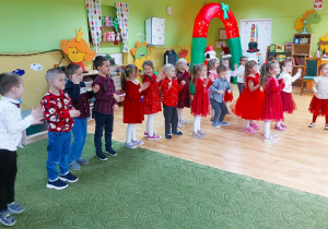 Dzieci stoją ustawione jedno za drugim