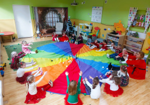 Dzieci siedzą wokoło chusty animacyjnej