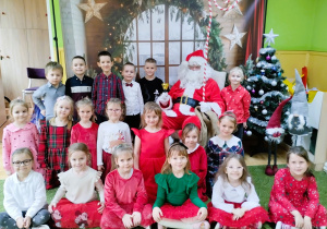 Dzieci pozują do zdjęcia z Mikołajem