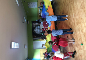 Dzieci bawią się trzymając razem chustę animacyjną