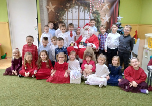 Dzieci pozują z Mikołajem do zdjęcia