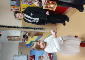 Dziewczynka odbiera płomień od harcerzy