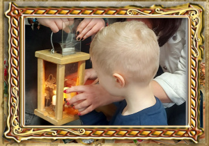 Chłopiec podpala świecę od Betlejemskiego Światła Pokoju