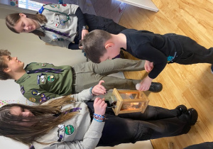 Chłopiec odpala płomyk od harcerzy