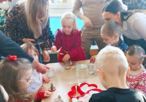 Dzieci tworzą śnieżne kule ze słoików