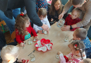 Dzieci tworzą śnieżne kule ze słoików