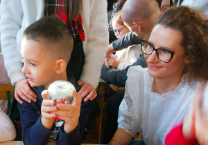 Chłopiec trzyma śnieżną kulę wykonaną ze słoiczka