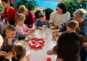 Dzieci tworzą śnieżne kule ze słoików