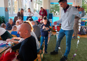 Rodzice z dziećmi tworzą ozdoby choinkowe