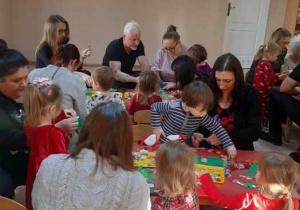 Rodzice wykonują z dziećmi wianuszki świąteczne