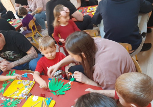 Rodzice wykonują z dziećmi wianuszki świąteczne