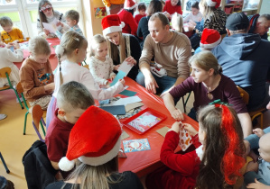 Dzieci i rodzice tworzą kartki Bożonarodzeniowe
