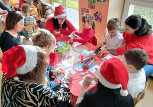 Dzieci i rodzice tworzą kartki Bożonarodzeniowe
