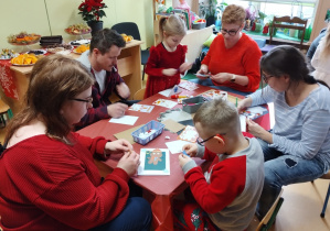 Dzieci i rodzice tworzą kartki Bożonarodzeniowe