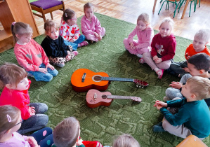 Dzieci siedzą w kole na dywanie