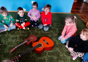 Dzieci siedzą w kole na dywanie